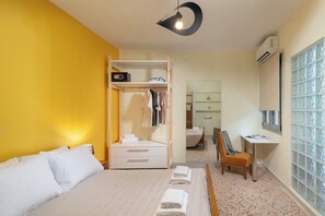 A hotel room with a bed, a wardrobe, a desk, and a chair.
