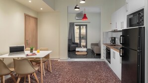 Una cucina moderna con frigorifero, piano cottura e forno a microonde. C'è una zona pranzo con tavolo e sedie.