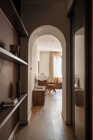 A hallway with a wooden floor, a bookshelf, and a dining area with a table and chairs. - A Stay In Hanoi (Hanoi)