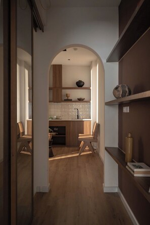 A modern kitchen with wooden cabinets, a tiled backsplash, and a central island. - A Stay In Hanoi (Hanoi)