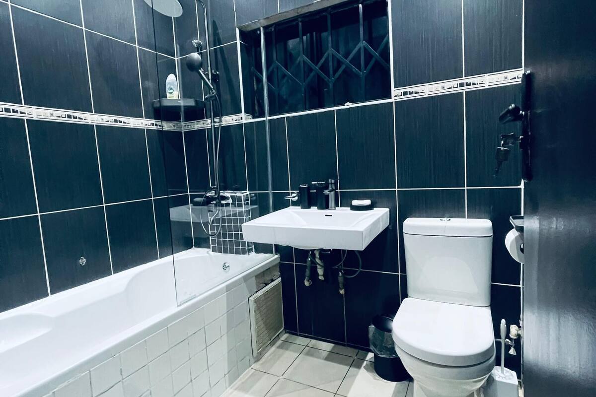 Een moderne badkamer met een bad, toilet en wastafel.