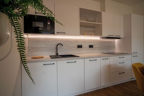 Appartement, uitzicht op binnenplaats | Privékeuken | Een koelkast, een oven, een kookplaat, een kinderstoel
