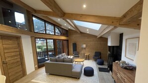A spacious living area with a sofa, chairs, a coffee table, and a fireplace.
