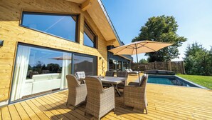 A modern house with a wooden deck, outdoor furniture, and a swimming pool. - "Whisper of Alpacas" chalet (Oederan)