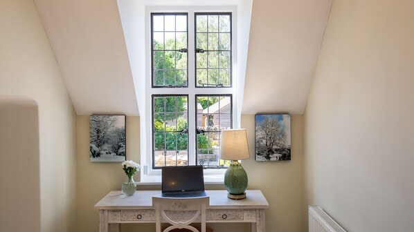 A study with a desk, laptop, lamp, and two framed pictures on the wall. - Hopscotch House - Stanton near Broadway (Near Broadway)