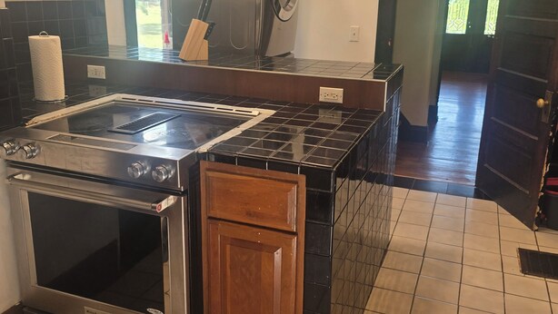 A kitchen with a stainless steel stove, a refrigerator, and a wooden cabinet. - Spacious 5-bedroom house in brilliant Cincinnati with WiFi, AC (Cincinnati)