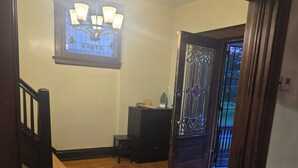 A spacious room with wooden flooring, a chandelier, a window with a view, and a door leading outside. - Spacious 5-bedroom house in brilliant Cincinnati with WiFi, AC (Cincinnati)