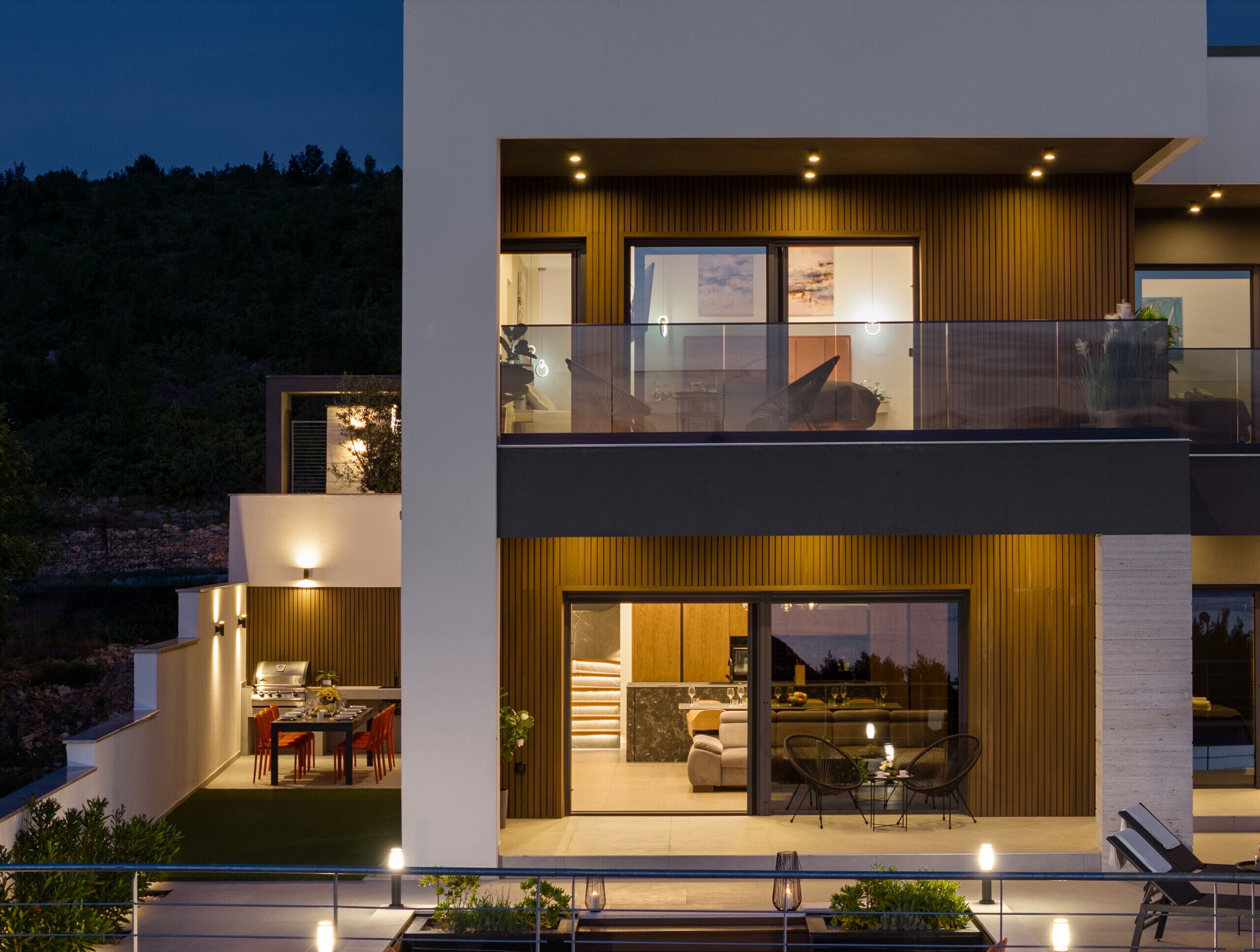 A modern two-story house with a balcony, a dining area, and a kitchen.