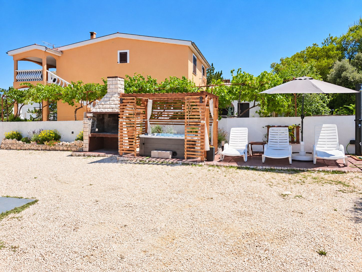 Une terrasse avec un barbecue, des meubles d’extérieur et une piscine.