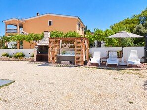 A patio with a barbecue grill, outdoor seating, and a pool. - Apartment Didovi Dvori 2 with jacuzzi (Ražanac)