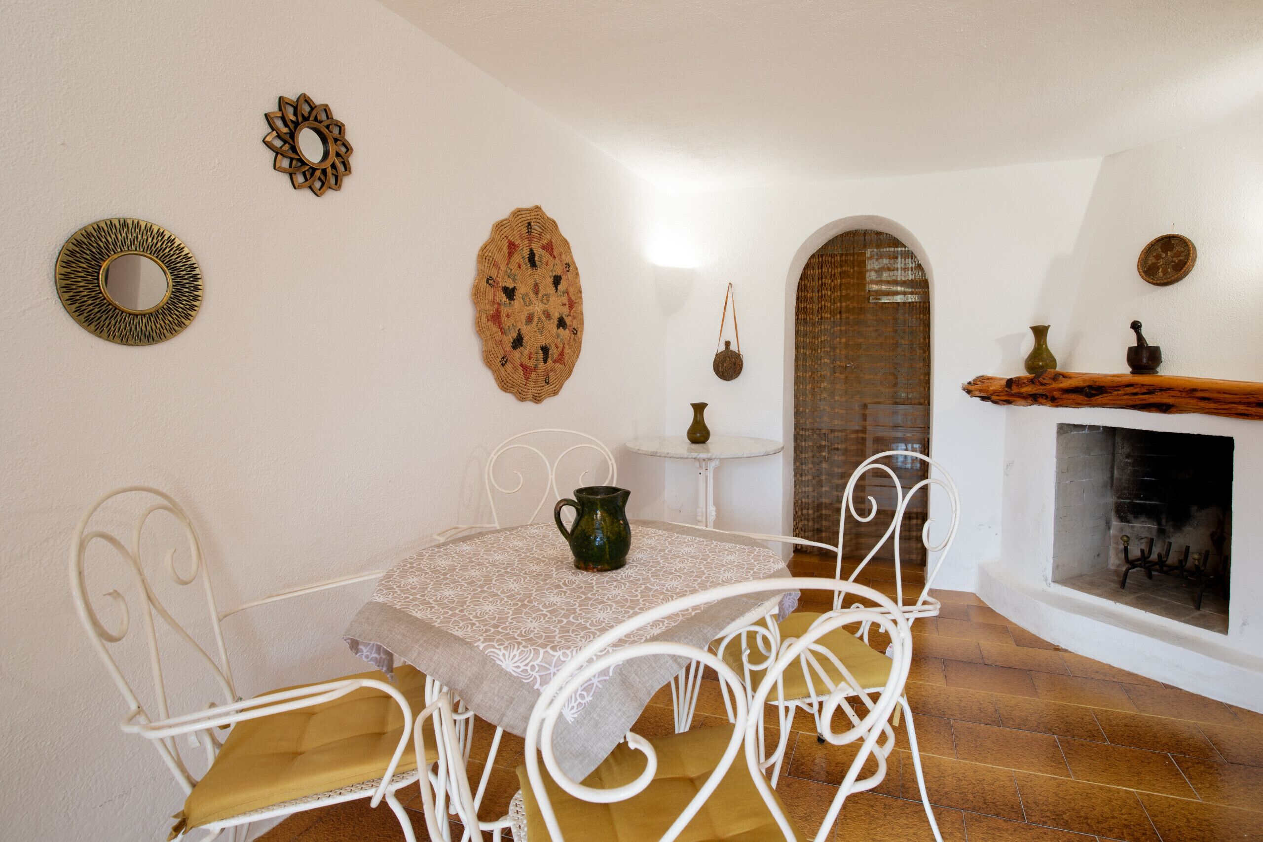 Un espace repas comprenant une table et des chaises, une cheminée et des œuvres d’art décoratives murales.