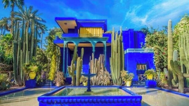 A building with a blue facade, surrounded by cacti and palm trees. - Charming 2-bedroom apartment in lovely Marrakesh with AC, Pool (Marrakesh)