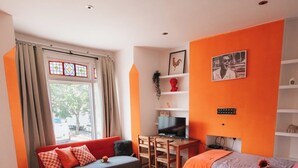 A modern bedroom with a large bed, a desk, and a window with curtains. - Chelsea Orange Residence (London)