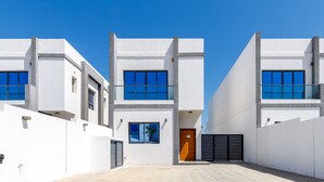 Un edificio moderno con fachada simétrica, ventanas amplias y una entrada central.