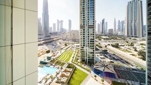 A high-rise building with a rooftop pool and landscaped areas.
