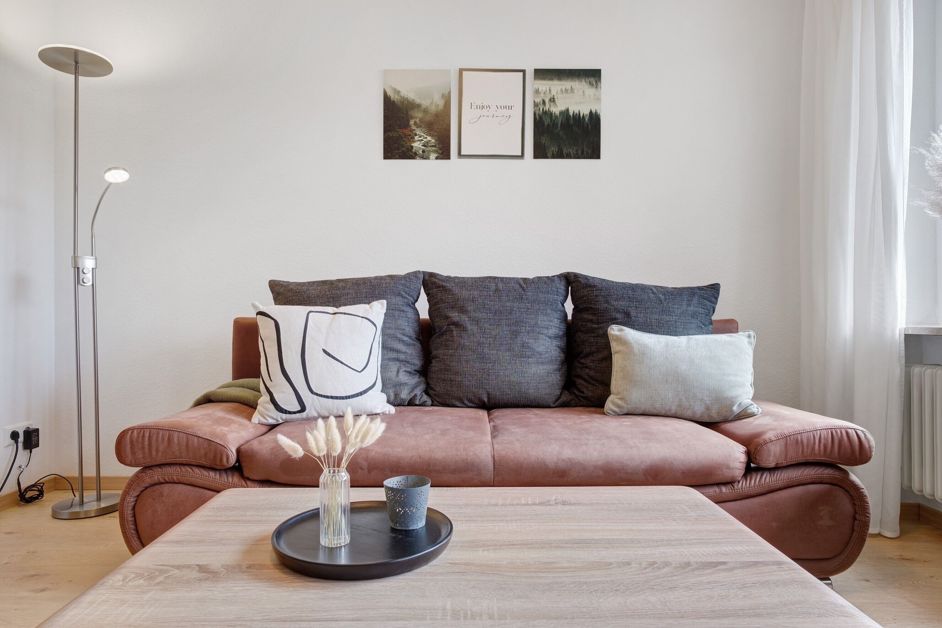 A modern living room with a sofa, a coffee table, and wall art.