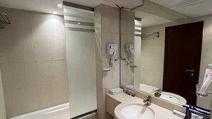 A modern bathroom with a bathtub, a sink, and a mirror. - Mayon Hotel (Riyadh)
