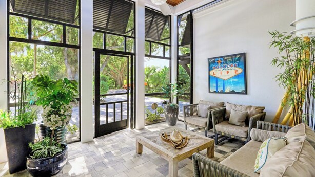 A spacious living area with a large window, a ceiling fan, and a comfortable seating arrangement.