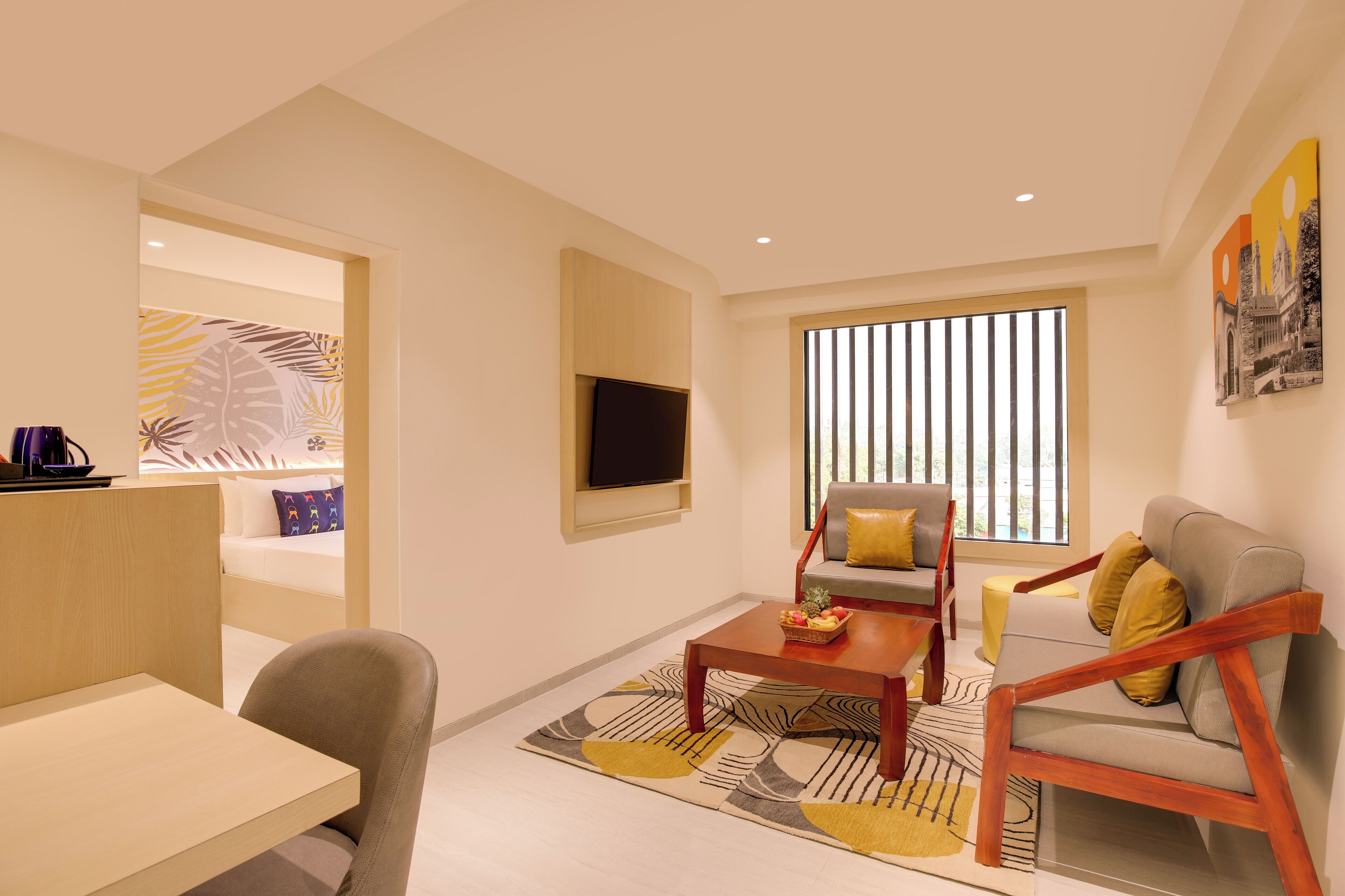 Una sala de estar moderna con un sofá, sillones, una mesa de centro y un televisor montado en la pared.