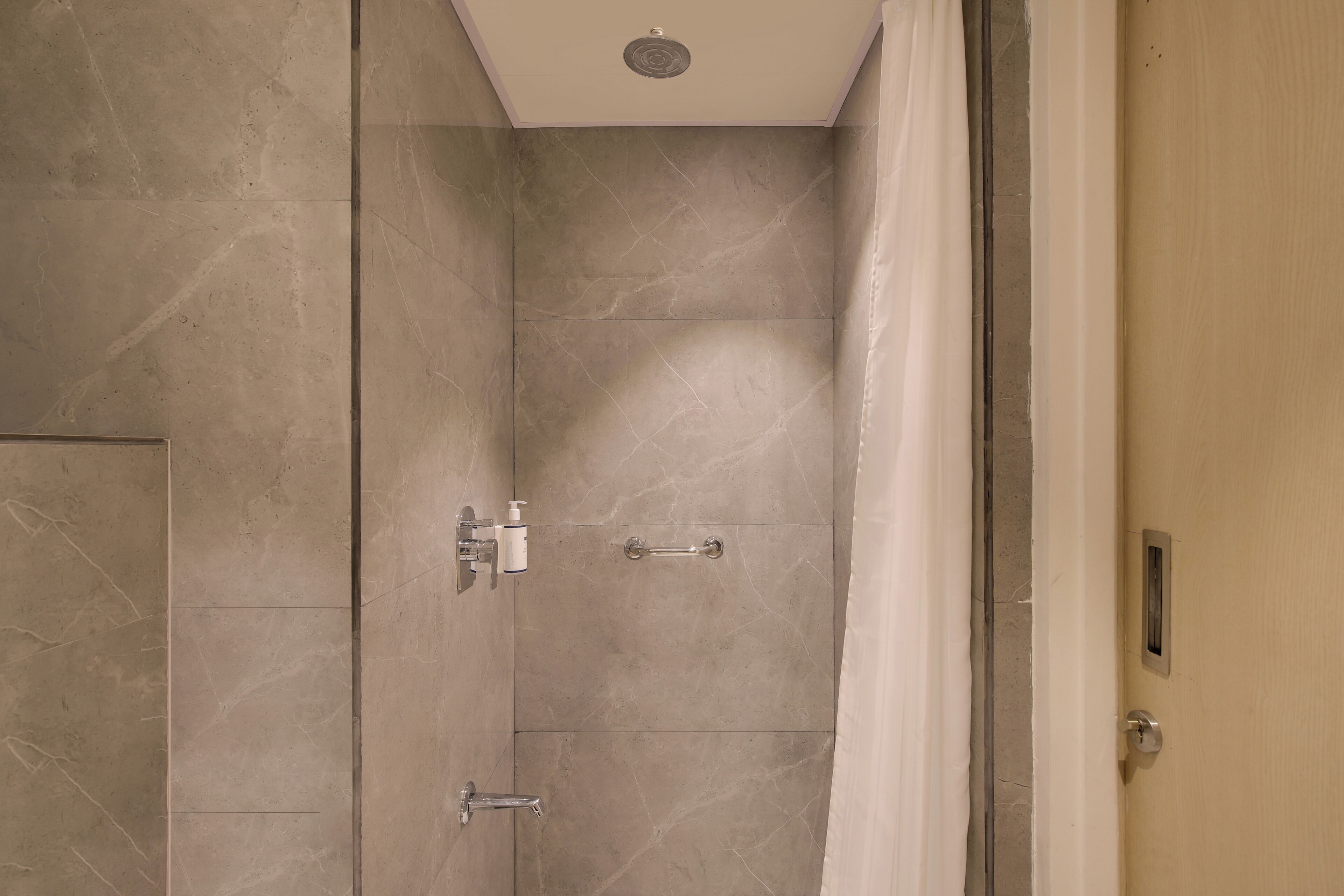 A bathroom with a shower, a toilet, and a sink.