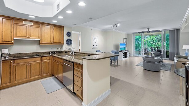 A modern kitchen with wooden cabinets, granite countertops, and recessed lighting.