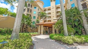 A hotel with a central courtyard, palm trees, and a tiled entrance.