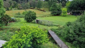 A rural landscape with a wooden bridge, a fenced area, and various trees. - Yellowstone | quiet country farmhouse | fast internet (Rydal)