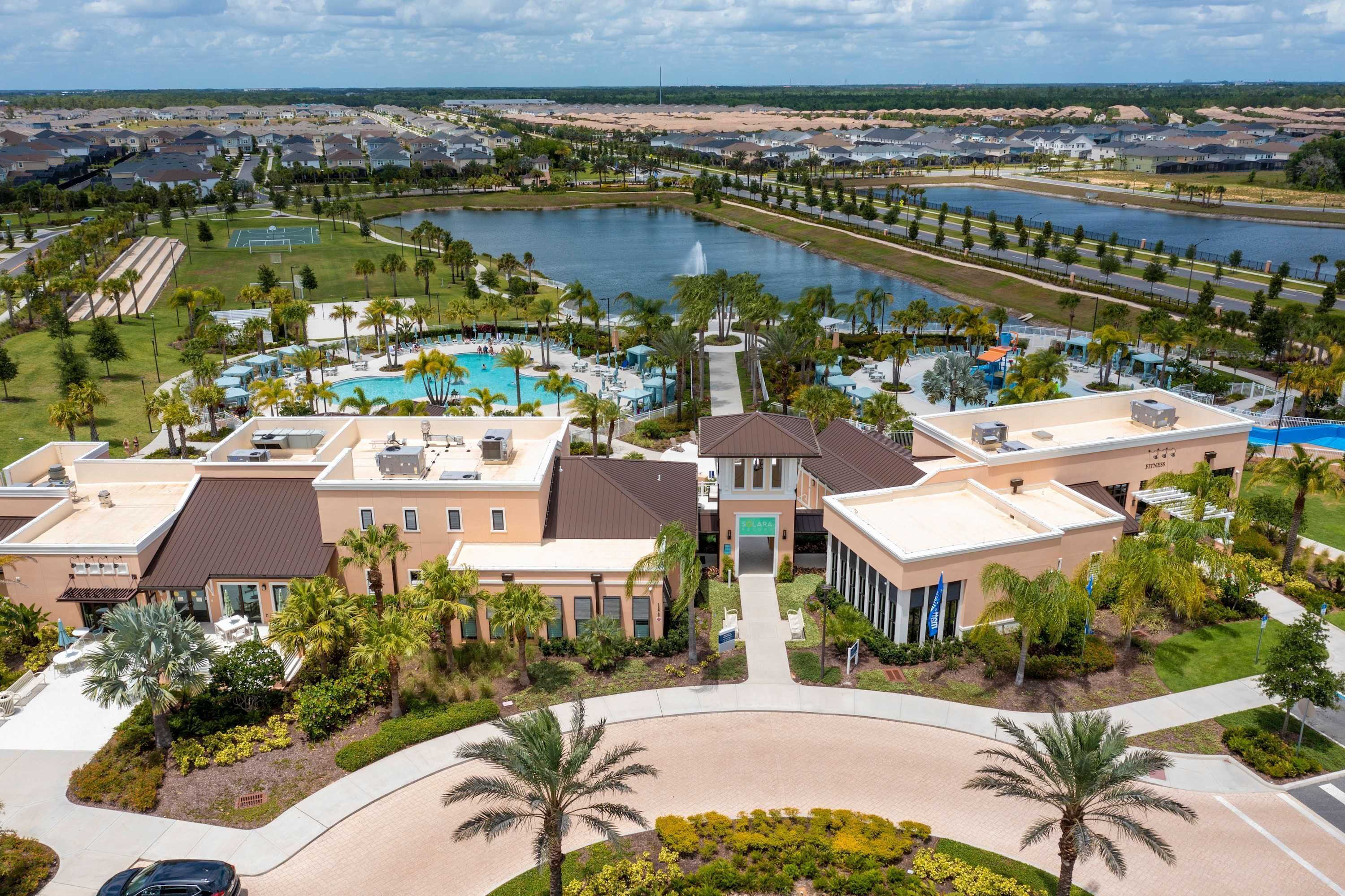 A resort with a swimming pool, tennis courts, and a lake view.