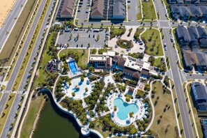 An aerial view of a resort with multiple swimming pools, a central building, and surrounding roads. - 9140 Fun for the Family in Orlando Pool and Games (Kissimmee)