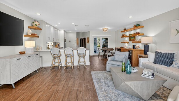 Un espacio habitable amplio con una cocina moderna, zona de comedor y un área de descanso con sofá y mesa de centro.