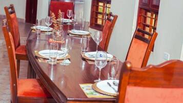 A dining table set for six with chairs, a decorative centerpiece, and a refrigerator in the background.