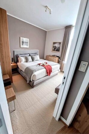 A modern bedroom with a bed, bedside tables, a nightstand, a dresser, and a window with curtains. - Résidence Rachel 23 - Shape - Mons (Mons)