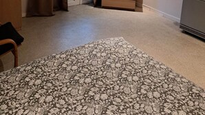 Une pièce comprenant un lit, une commode, un téléviseur et une porte avec des rideaux.