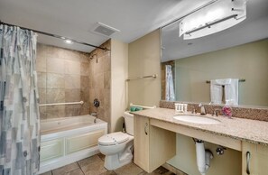 Et moderne badeværelse med badekar, toilet og vask.