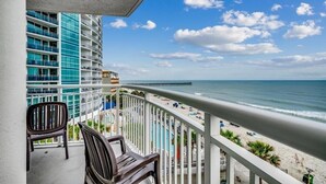 Ein Balkon mit Blick auf Strand und Meer.