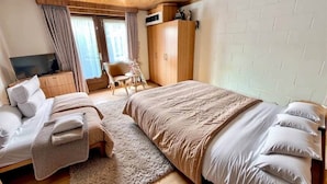 A bedroom with a bed, a TV, a wardrobe, and a chair. - Résidence Rachel 25 - Shape - Mons (Mons)