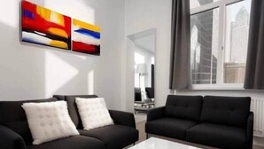 A modern living room with two black sofas, a white coffee table, and abstract art on the wall. - Jumet 242 D'Bruxelles-charleroi-airport (Charleroi)