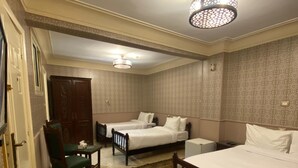 A hotel room with two beds, a desk, a chair, and a small table. -  ALRashedy Hotel Powered by Boutique (Cairo)