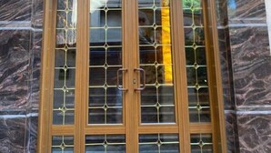 A double wooden door with glass panels and a semi-circular arch above it, set against a marble wall with two wall-mounted lights. -  ALRashedy Hotel Powered by Boutique (Cairo)