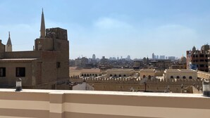 A cityscape with a prominent mosque featuring a tall minaret and a dome, surrounded by various buildings and a clear sky. -  ALRashedy Hotel Powered by Boutique (Cairo)