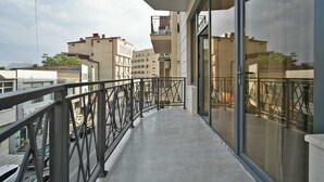 A balcony with a metal railing, large windows, and a view of surrounding buildings. - 2-bedroom apartment in fantastic Yerevan with WiFi, AC (Yerevan)