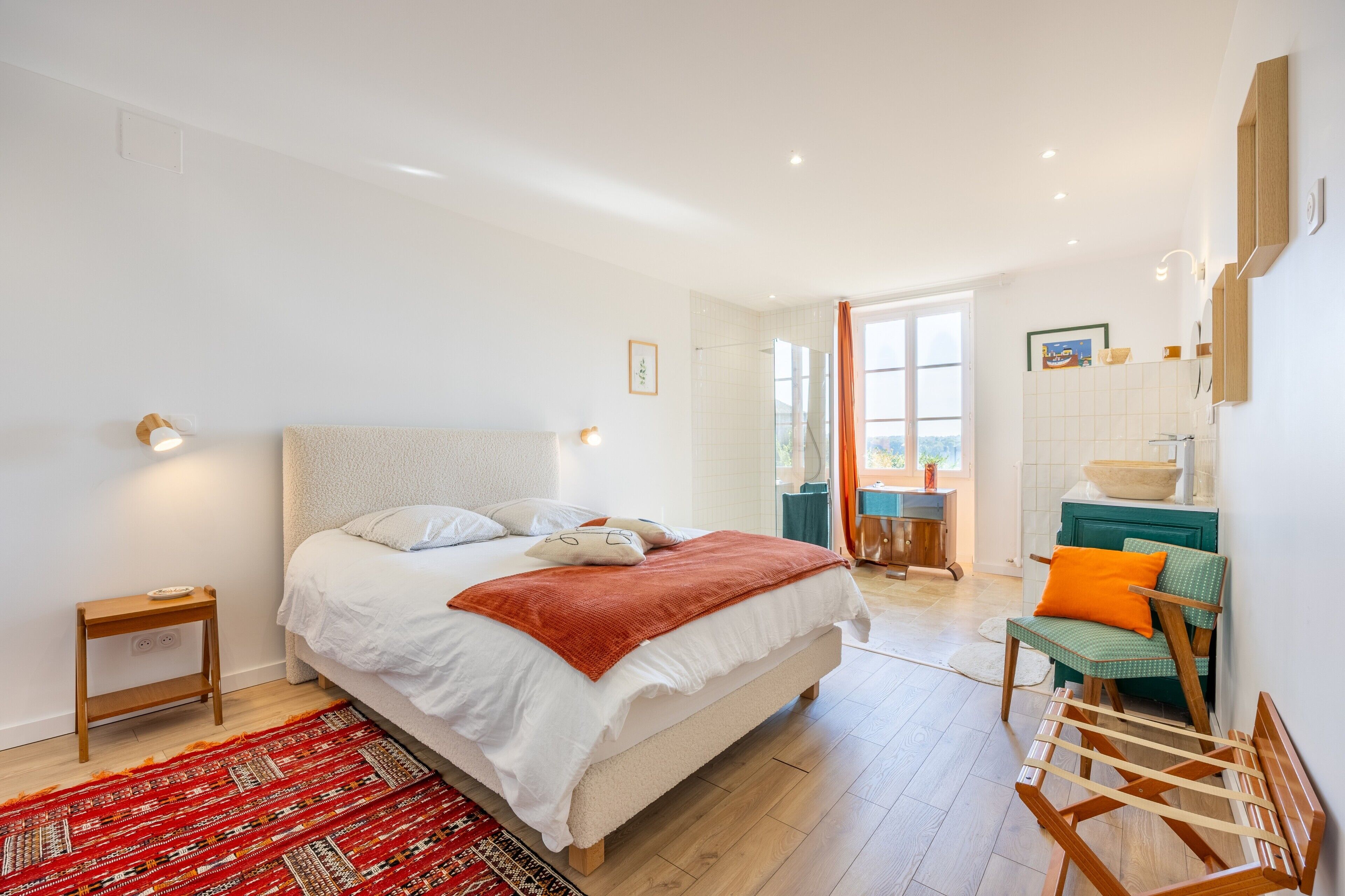 Quarto moderno com uma cama grande, mesa de cabeceira e vista para a cidade.