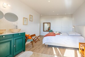 A bedroom with a bed, a green dresser, a mirror, and a chair. - Gîte du Val d’Egray – Charming House with Garden in Champdeniers (Champdeniers)