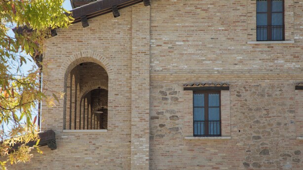 A brick building with arched windows and stone accents. - Casale Madonna Grande (Campomarino)