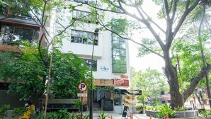 A modern building with a storefront, a no parking sign, and a pedestrian crossing. - Stopover Backpackers Stay (Bengaluru)