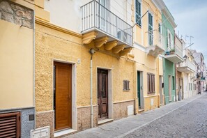 A row of colorful buildings with balconies, doors, and windows.