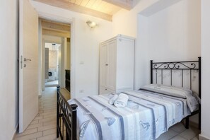Une chambre à coucher avec un lit, une armoire et une salle de bain visible au fond.
