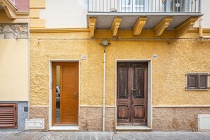 A building facade with two wooden doors, numbered 41 and 39, and a balcony above.