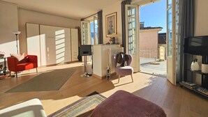 Een moderne woonkamer met een bank, een fauteuil, een salontafel en een televisie.