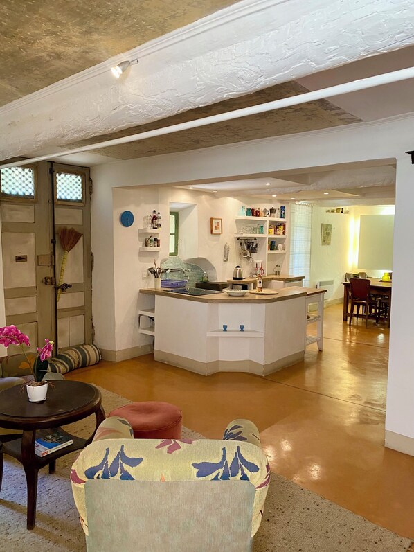 A spacious living area with a kitchen island, a dining table, and a sofa. - Lo Cantou" vacation home (Camplong-d'Aude)
